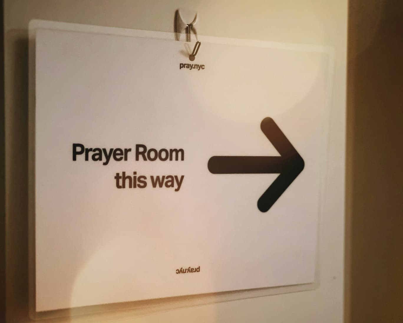 Znak s puščico za sobo za molitev – “Prayer Room this way”.